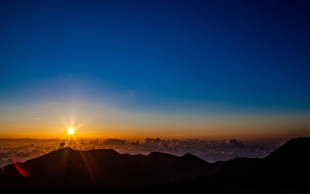 Visitors watching first light over the crater from the summit of Haleakala on Maui